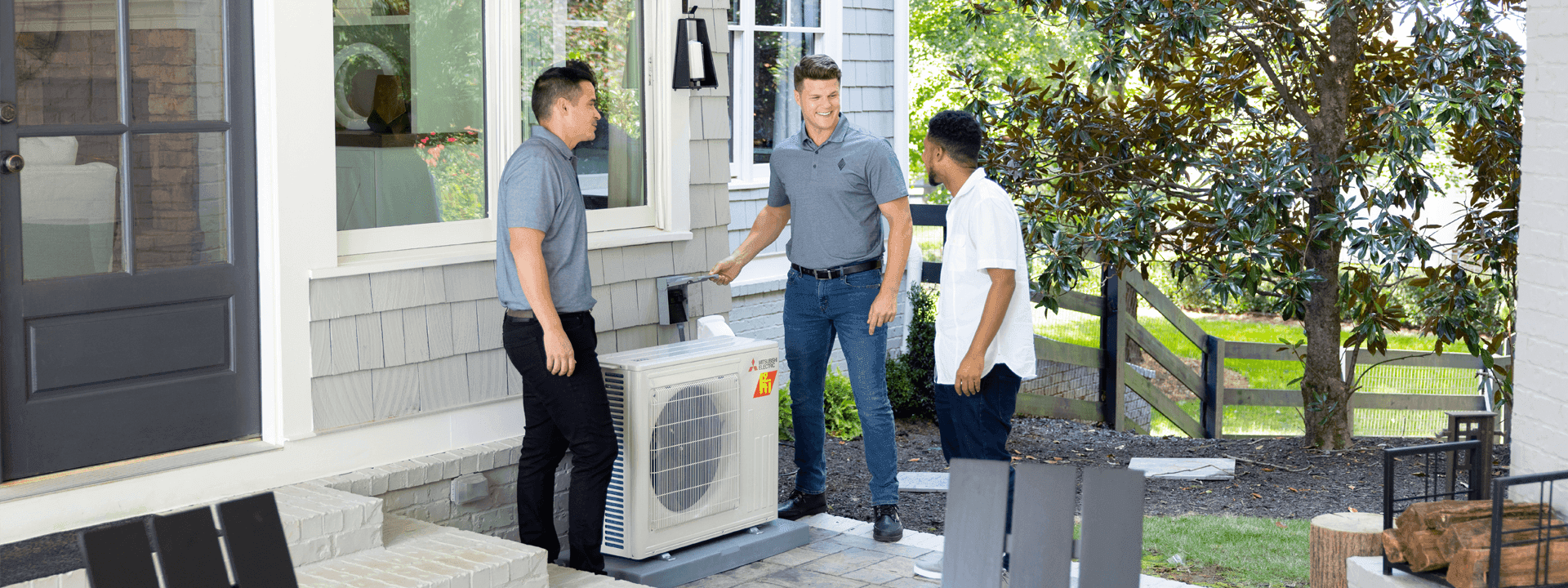 Contractors demonstrating newly installed heat pump to homeowner