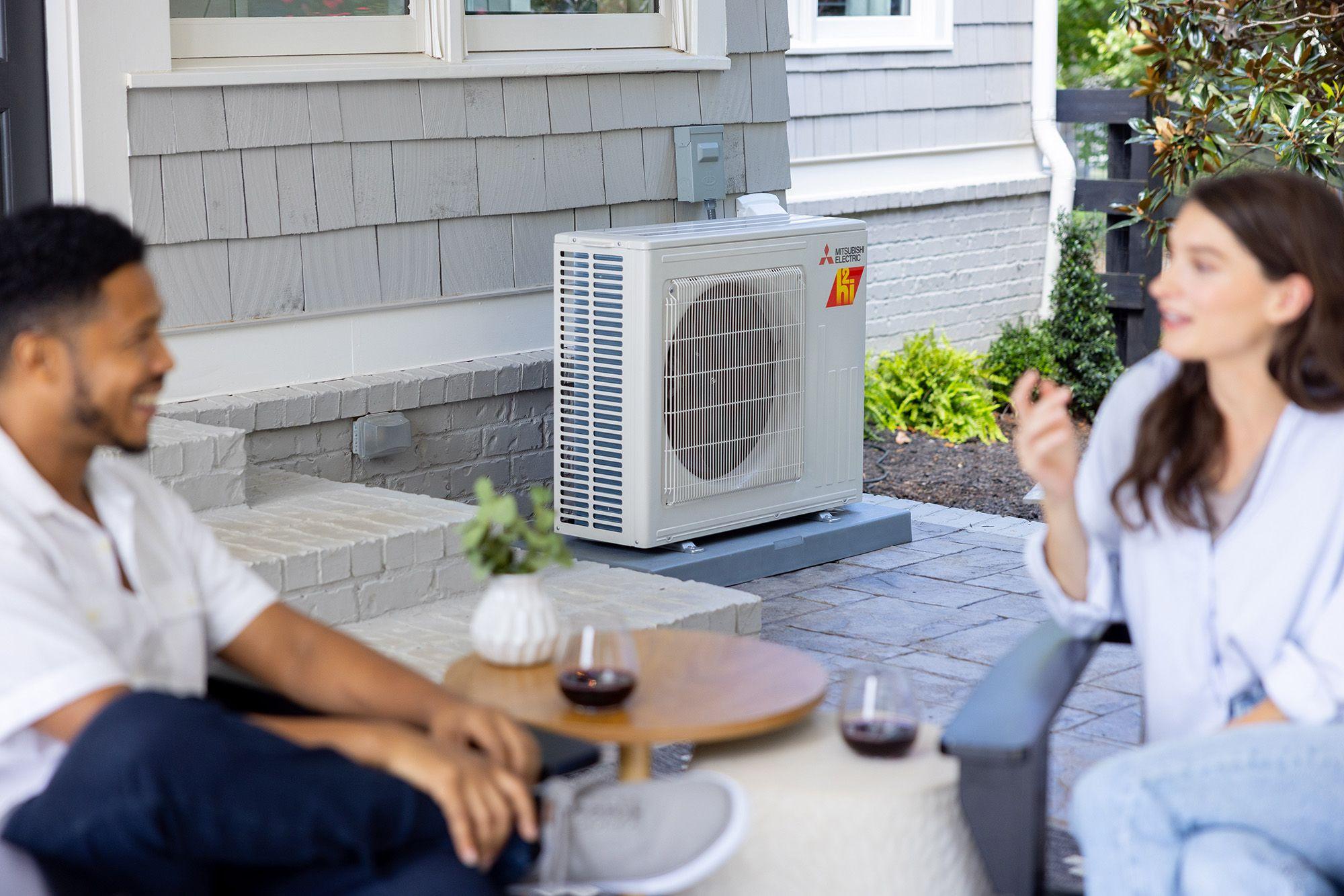 Mitsubishi Electric outdoor unit on patio with happy young couple in foreground