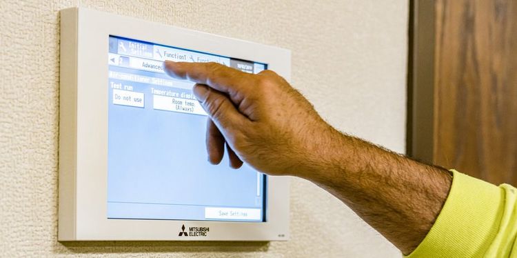 man using touchscreen panel to control mitsubishi electric commercial HVAC equipment