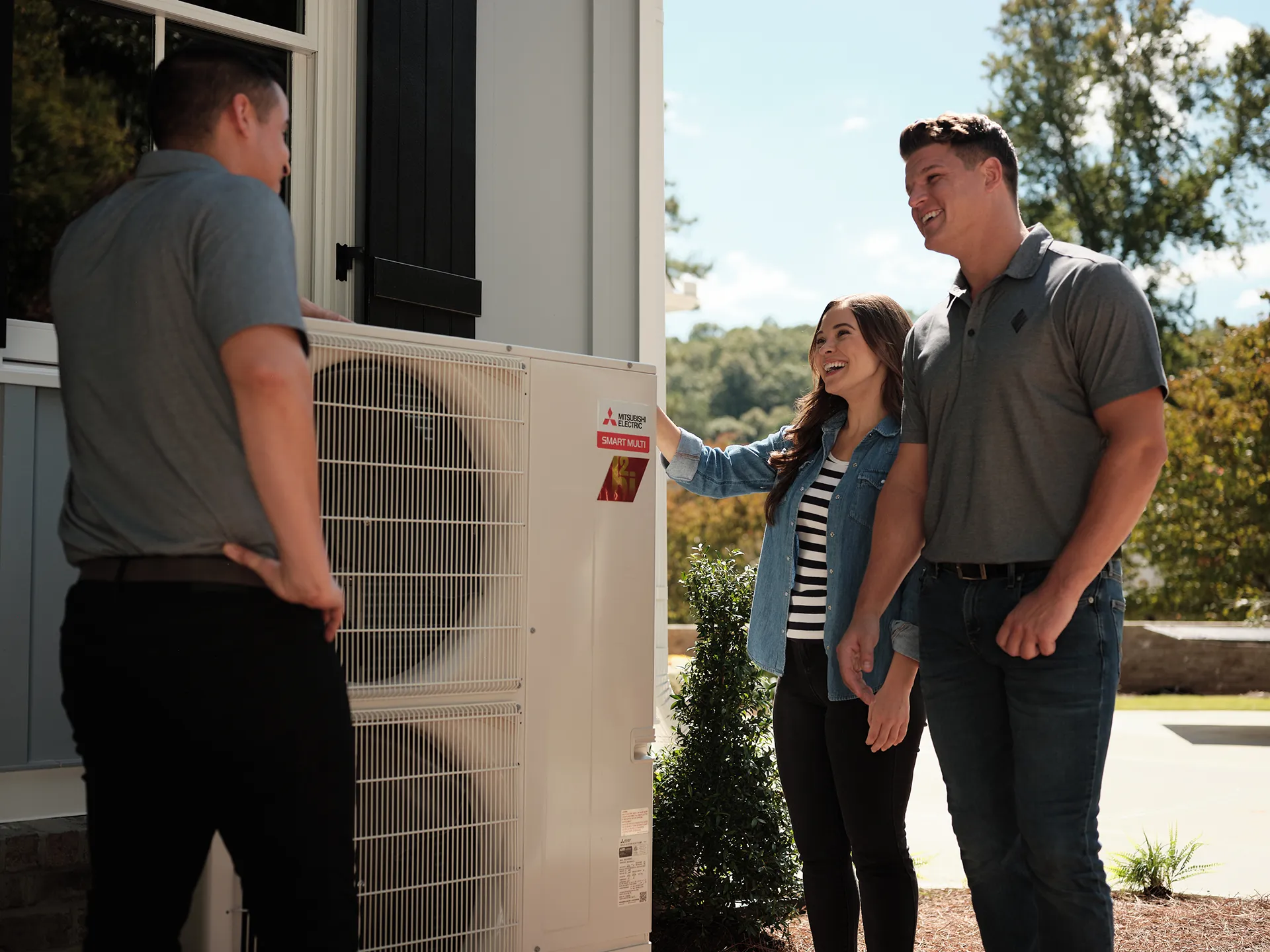 Contractor discussing newly installed heat pump with homeowners