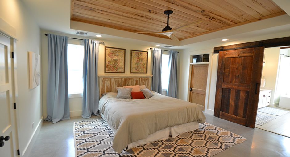 Owners' suite with barn door leading to bathroom
